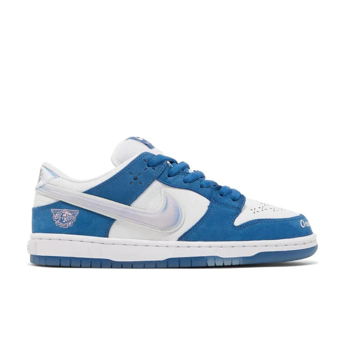 Nike SB Dunk Low "Born x Raised" sneaker side view showing white leather, blue nubuck, iridescent Swoosh, and unique heel embroidery | Collaboration SB Dunks