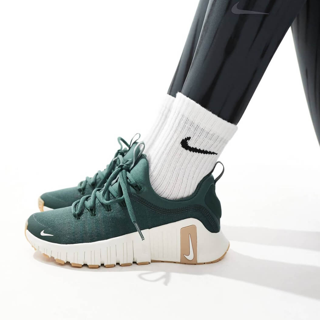 Woman wearing green Nike Free Metcon sneakers during a gym workout.