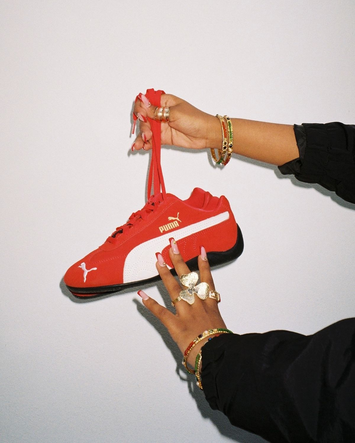 Puma speedcat red held by shoelaces