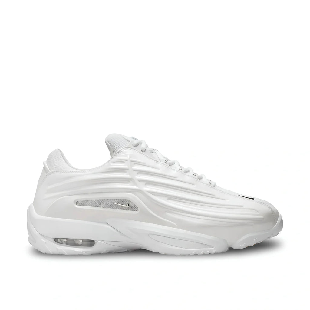 Side view of Nike NOCTA Hot Step 2 in white, showing premium leather upper, silver swoosh plus mesh, and sculpted sole.