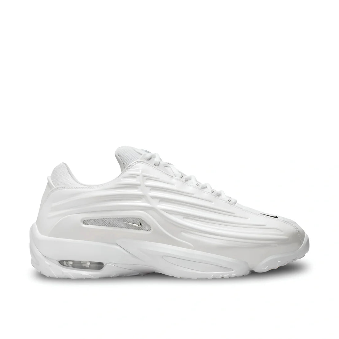 Side view of Nike NOCTA Hot Step 2 in white, showing premium leather upper, silver swoosh plus mesh, and sculpted sole.