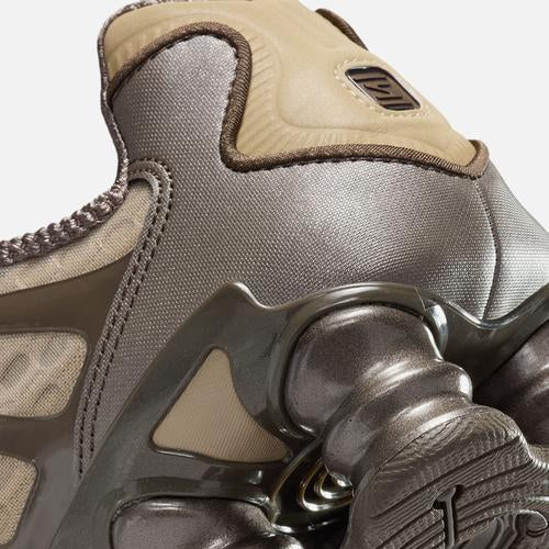 Close-up of a gray athletic shoe with a unique sole design on a white background